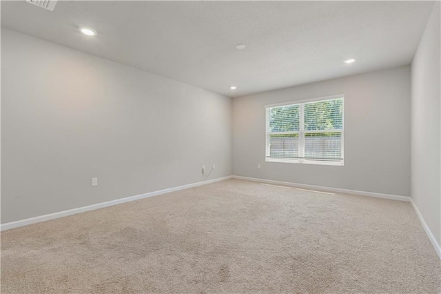 unfurnished room featuring light carpet