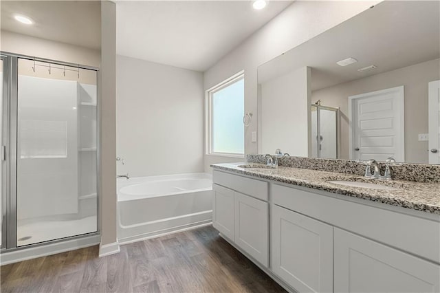 bathroom with hardwood / wood-style floors, vanity, and shower with separate bathtub