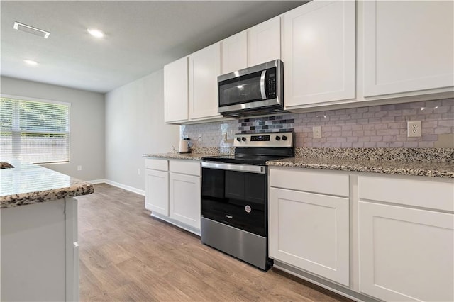 kitchen featuring white cabinets, stainless steel appliances, and light hardwood / wood-style floors