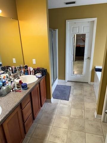 bathroom featuring tile patterned flooring, vanity, and plus walk in shower