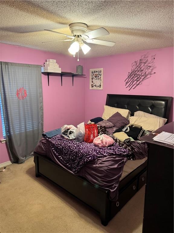 carpeted bedroom featuring ceiling fan and a textured ceiling