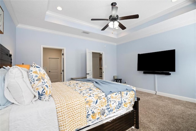 carpeted bedroom featuring a tray ceiling, ornamental molding, and ceiling fan