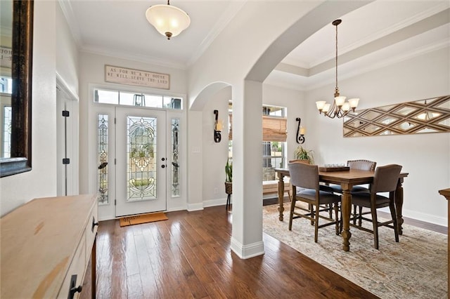 entrance foyer featuring crown molding, dark wood-type flooring, and a chandelier