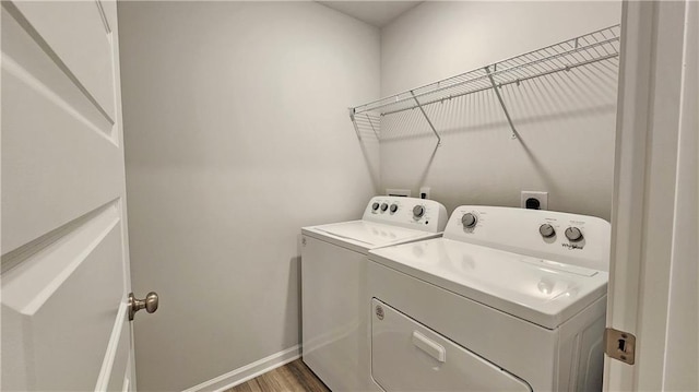 clothes washing area featuring hardwood / wood-style flooring and washing machine and clothes dryer