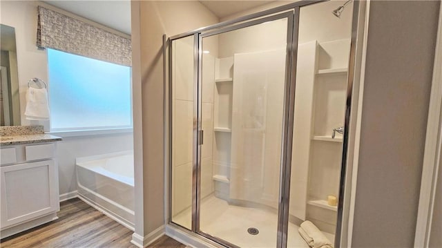 bathroom with vanity, hardwood / wood-style floors, and separate shower and tub