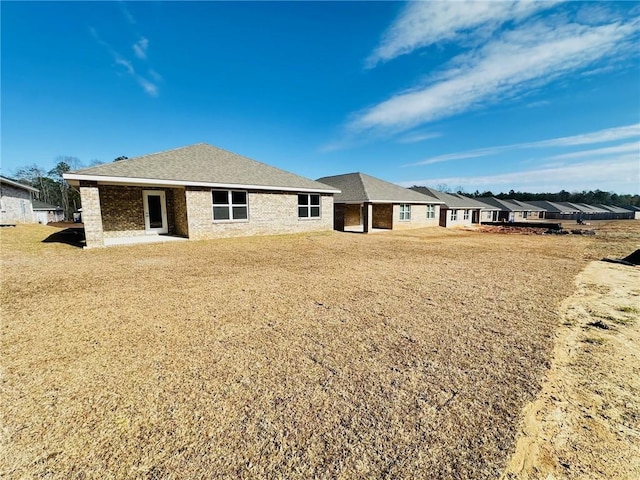 rear view of property with a yard and a patio area