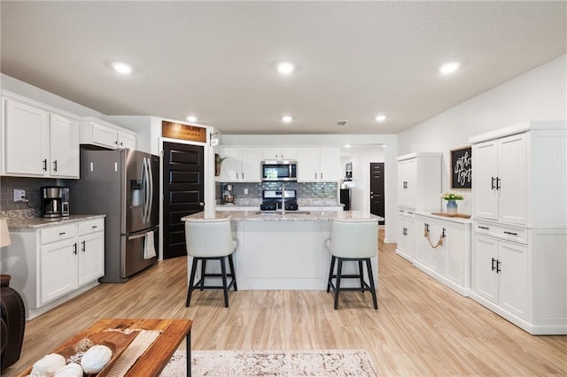 2526 Windmere Dr E, Semmes, AL 36575 - kitchen featuring white cabinetry, appliances with stainless steel finishes, and decorative backsplash