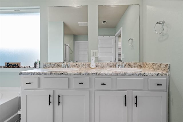 2526 Windmere Dr E, Semmes, AL 36575 - bathroom featuring double vanity, visible vents, a sink, and a garden tub