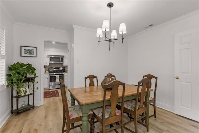4689 Oak Ridge Rd, Mobile, AL 36609 - dining space with light wood-style flooring, crown molding, a chandelier, and baseboards