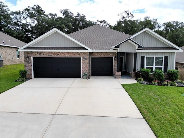 craftsman house with concrete driveway, a front lawn, a shingled roof, a garage, and brick siding