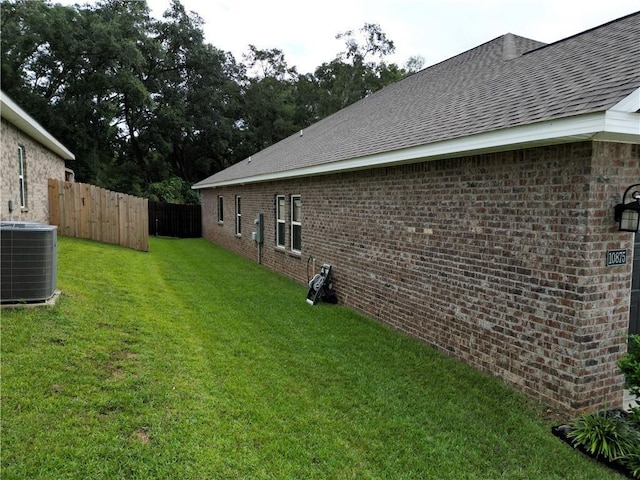 view of yard with fence and central AC