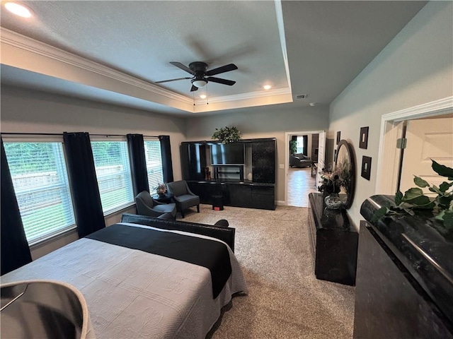 carpeted bedroom featuring a ceiling fan, crown molding, a tray ceiling, visible vents, and recessed lighting