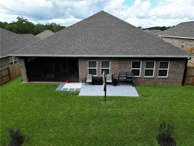 back of house featuring brick siding, a lawn, a patio, and a fenced backyard