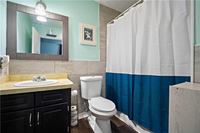 8920A Chunchula-Georgetown Rd, Chunchula, AL 36521 - full bathroom with vanity, toilet, a shower with shower curtain, tile walls, and wood finished floors