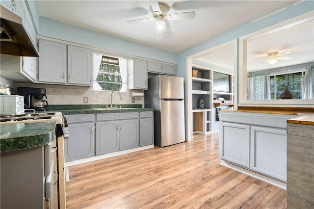 8920A Chunchula-Georgetown Rd, Chunchula, AL 36521 - kitchen featuring freestanding refrigerator, dark countertops, under cabinet range hood, white stove, and a ceiling fan
