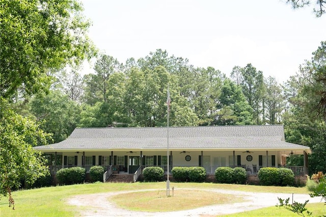 ranch-style home featuring covered porch and a front yard