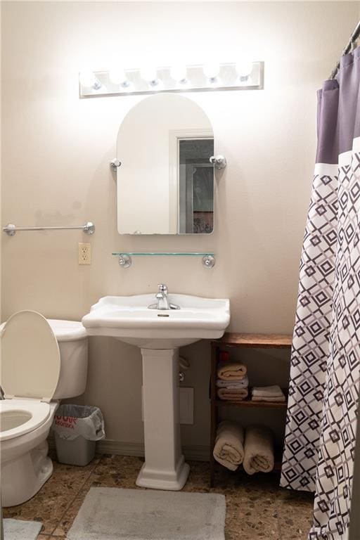 bathroom featuring toilet, tile flooring, and sink