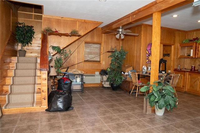 interior space with wood walls, tile flooring, and ceiling fan