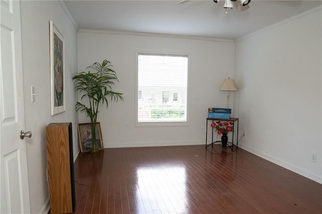 spare room with ornamental molding and dark wood-type flooring