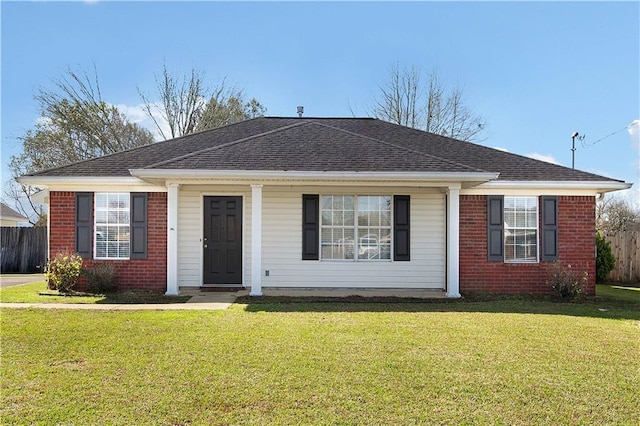 view of front of home featuring brick siding, roof with shingles, a front yard, and fence