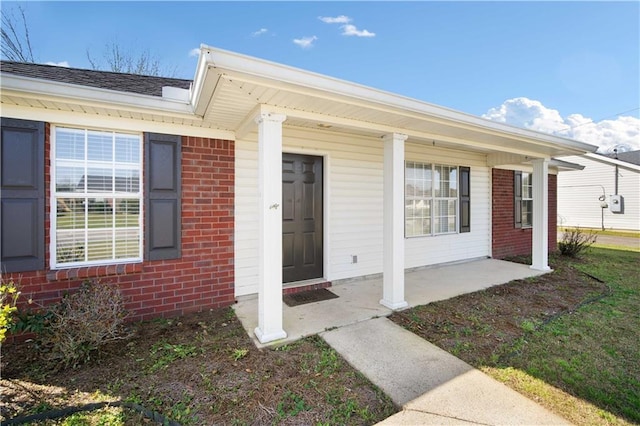 entrance to property featuring brick siding