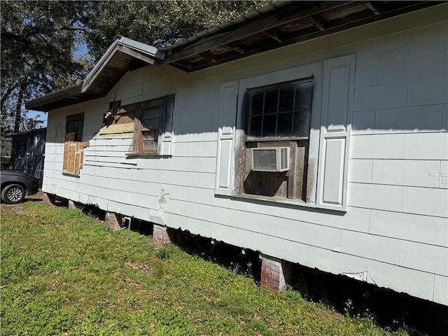 view of side of home with cooling unit and a yard