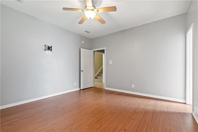 empty room with ceiling fan and hardwood / wood-style floors