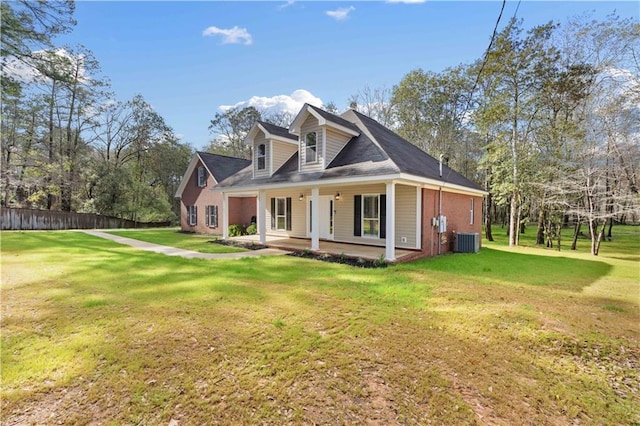 view of front of home with cooling unit, a porch, and a front yard