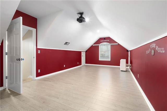 additional living space featuring light hardwood / wood-style flooring and lofted ceiling