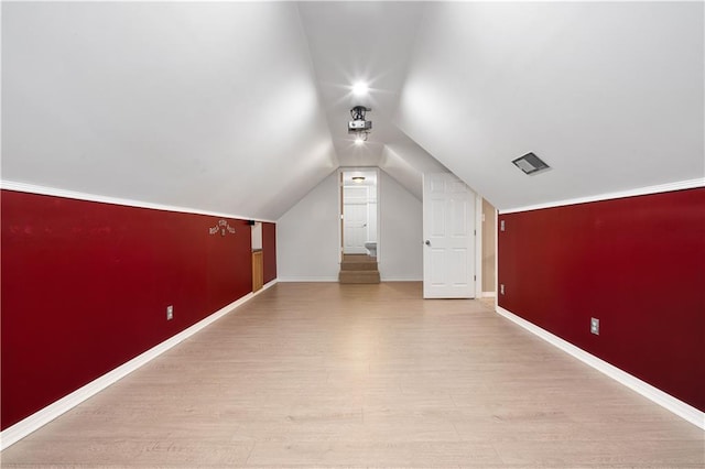 additional living space featuring light hardwood / wood-style flooring and lofted ceiling