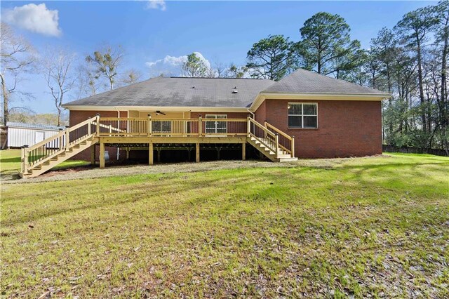 back of property with a deck and a yard