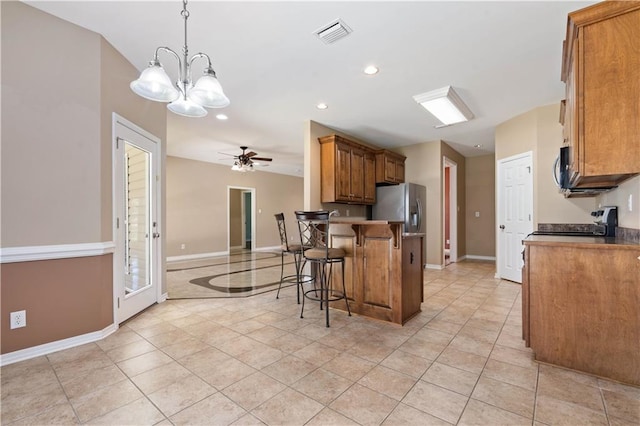 kitchen featuring appliances with stainless steel finishes, a breakfast bar area, ceiling fan, pendant lighting, and kitchen peninsula