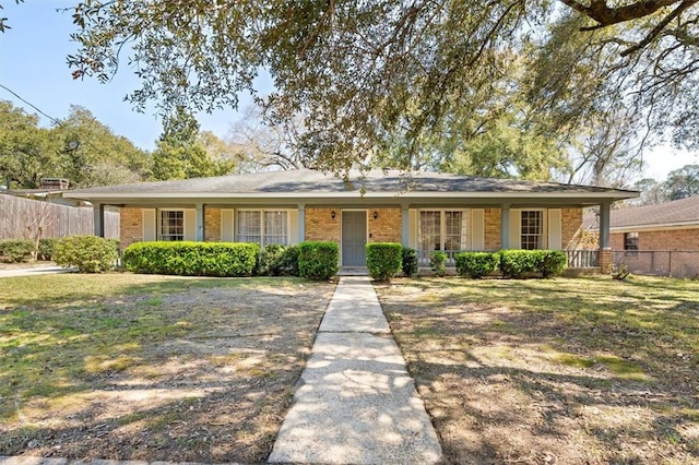 ranch-style house featuring brick siding, a front yard, and fence