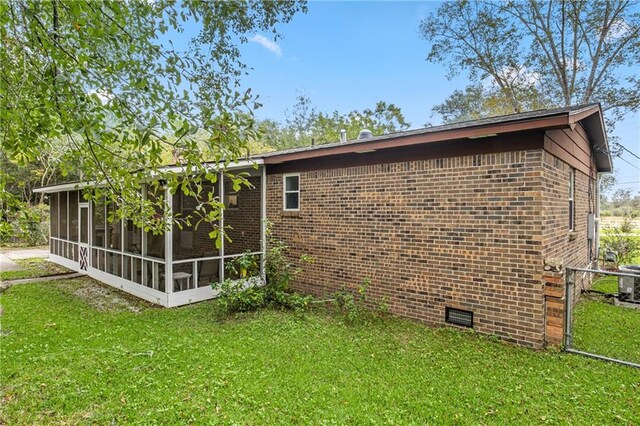 view of home's exterior with a yard and a sunroom