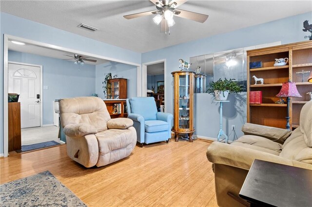 living room featuring light wood-type flooring and ceiling fan