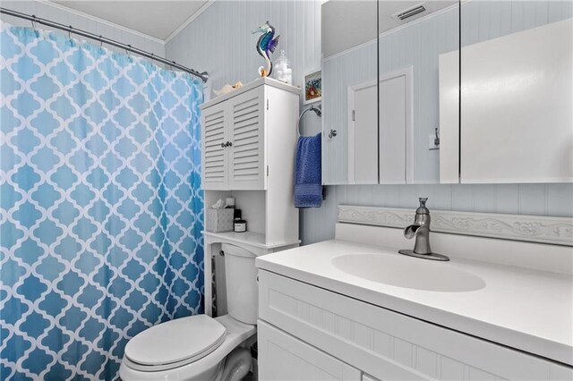 bathroom with crown molding, vanity, and toilet