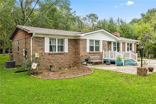 view of front of property featuring a front yard, a deck, a patio area, and central AC