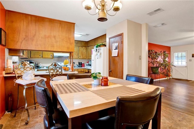 dining space with hardwood / wood-style flooring and an inviting chandelier