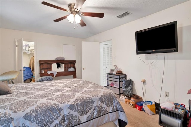 carpeted bedroom featuring a closet, ceiling fan, and a textured ceiling