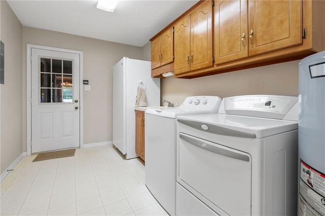 laundry area featuring washer and dryer, cabinet space, a sink, water heater, and baseboards