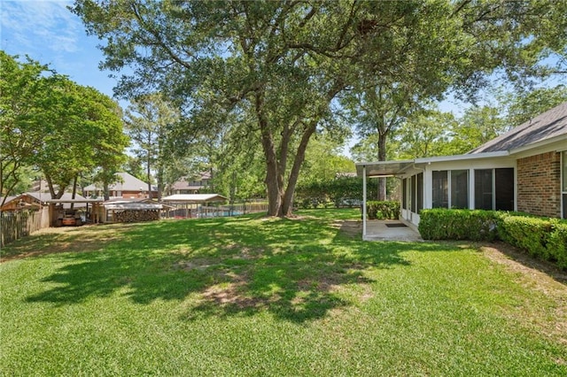 view of yard featuring a fenced backyard and a sunroom