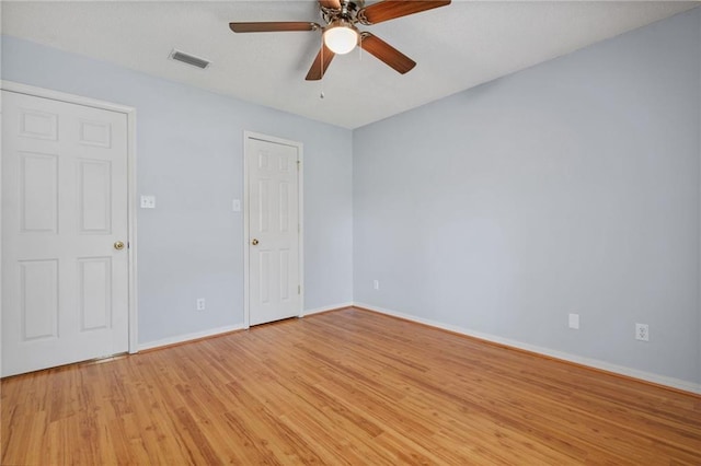 unfurnished room featuring visible vents, light wood-style flooring, ceiling fan, and baseboards