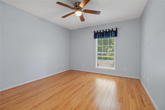 unfurnished room with baseboards, a ceiling fan, a textured ceiling, and wood finished floors