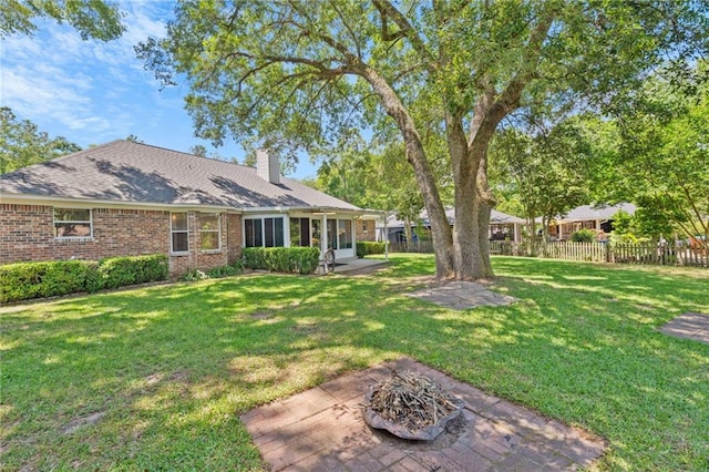 view of yard with a patio, fence, and an outdoor fire pit