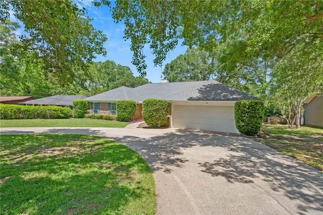 ranch-style house featuring a garage, a chimney, concrete driveway, and a front yard