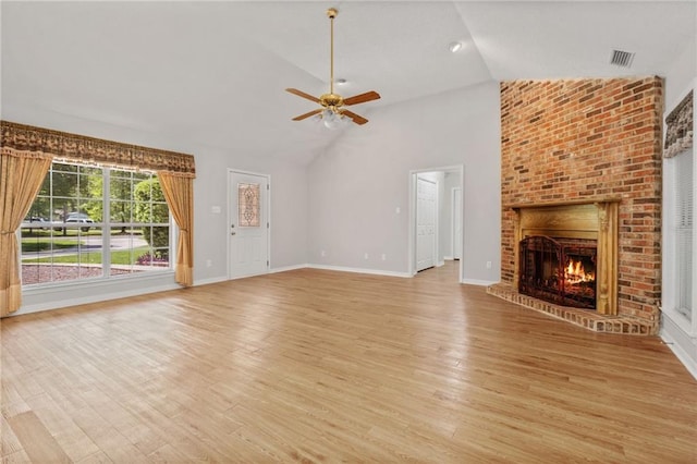 unfurnished living room featuring ceiling fan, a fireplace, high vaulted ceiling, light wood-style flooring, and visible vents