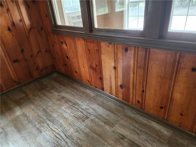 interior space with dark hardwood / wood-style flooring and wood walls