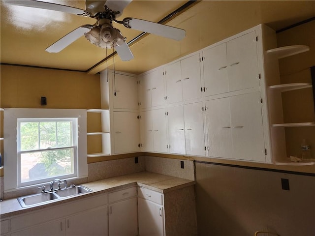 kitchen featuring white cabinets, ceiling fan, and sink