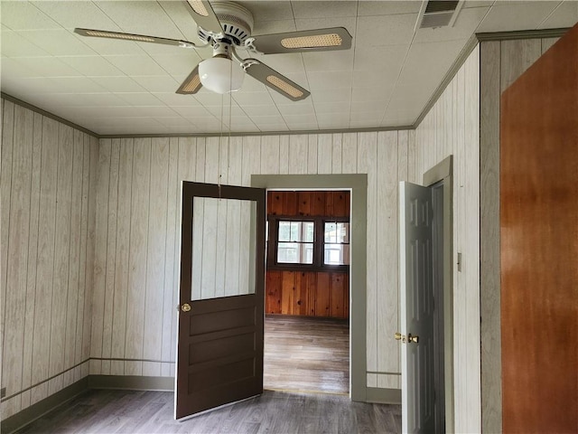 spare room featuring ceiling fan, wooden walls, and dark hardwood / wood-style flooring