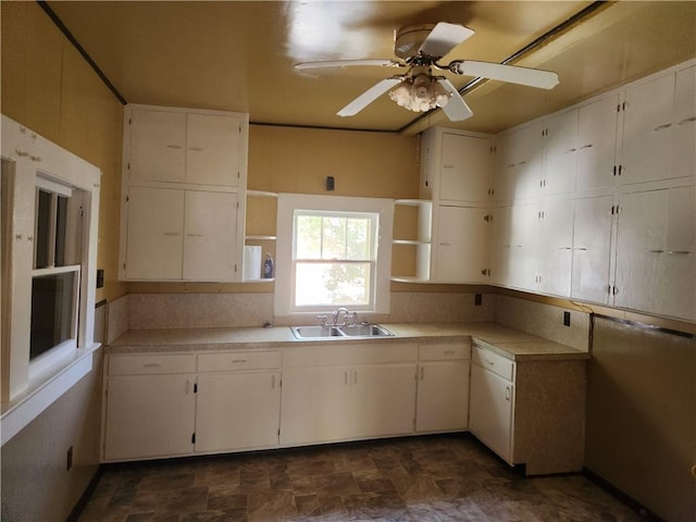 kitchen with white cabinetry, sink, and ceiling fan